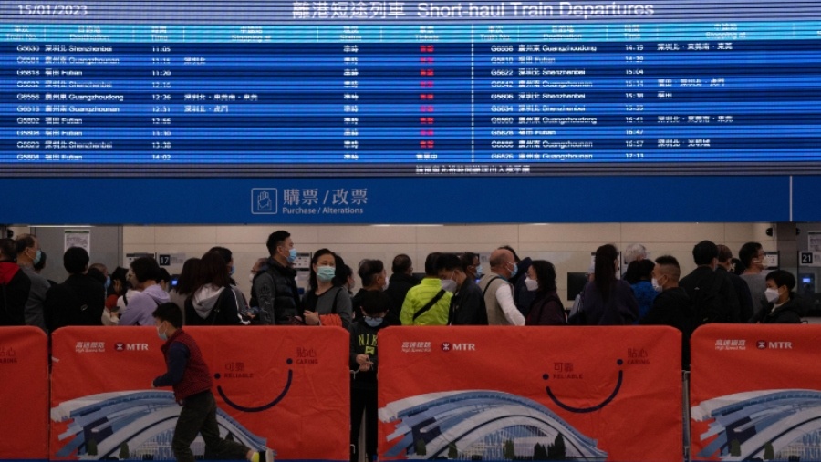 Para pemudik mengantre untuk membeli tiket di dalam aula keberangkatan di Stasiun Kowloon Barat, yang dioperasikan oleh MTR Corp., di Hong Kong, Minggu (15/1/2023). (Bertha Wang/Bloomberg)