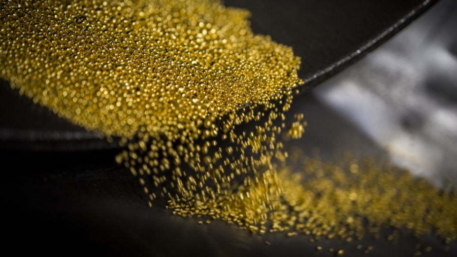Butiran emas dituangkan ke dalam wadah untuk selanjutnya diubah menjadi emas batangan di kilang MMTC-PAMP India (Bloomberg)