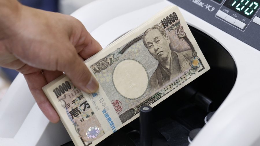 Karyawan menempatkan uang kertas 10.000 yen Jepang di mesin penghitung mata uang di cabang Resona Bank Ltd. di Tokyo, Jepang. (Kiyoshi Ota/Bloomberg)