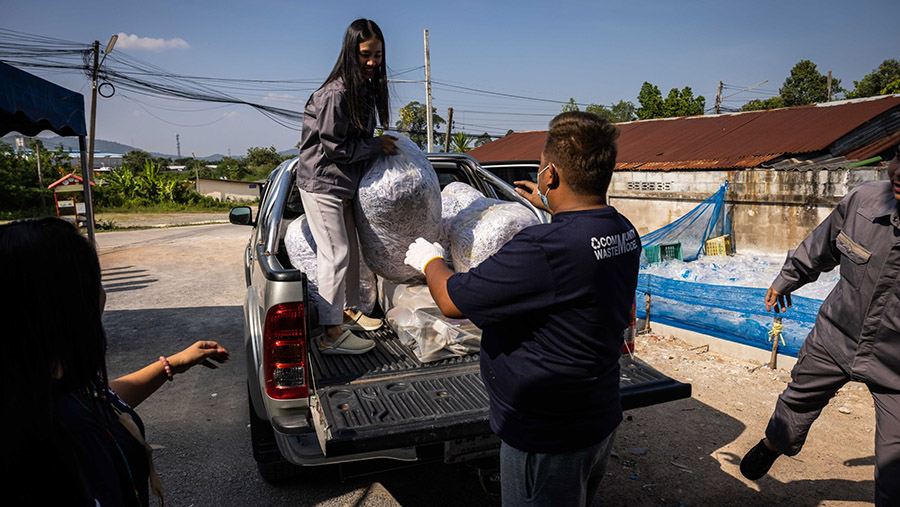 Relawan menurunkan berbagai jenis sampah dari truk di pusat daur ulang di Rayong, Thailand.  (Andre Malerba/Bloomberg)