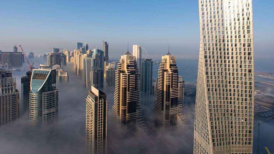 Kabut pagi menyelimuti gedung pencakar langit perumahan dan komersial di distrik Dubai Marina Dubai, Uni Emirat Arab. (Christopher Pike/Bloomberg)