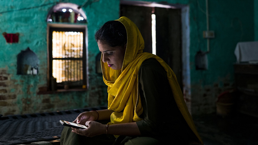 Kusum, mencari pekerjaan melalui ponselnya di desa Mundahera, Haryana, India, Selasa (11/10/2022). (Photogrpaher: Anindito Mukherjee/Bloomberg)