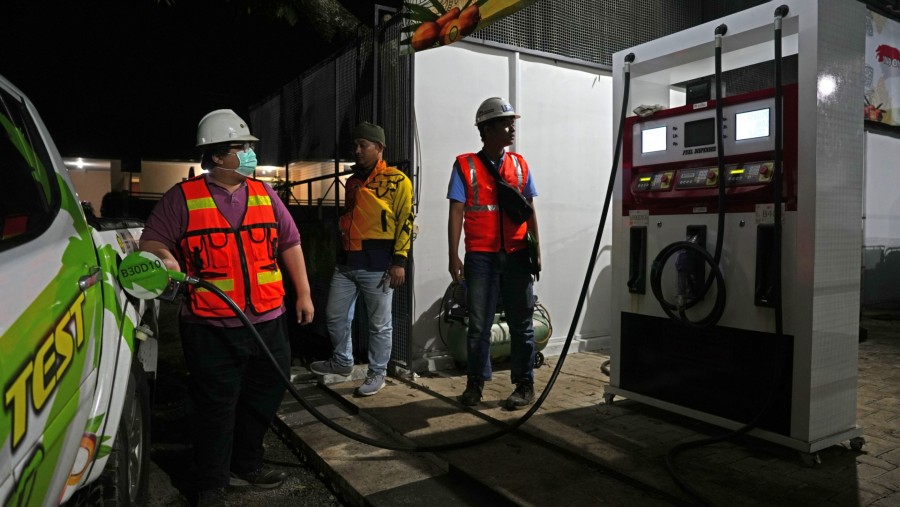 Seorang pekerja mengisi bahan bakar kendaraan saat uji jalan biodiesel berbahan dasar sawit 40% di Maribaya (Dimas Ardian/Bloomberg)