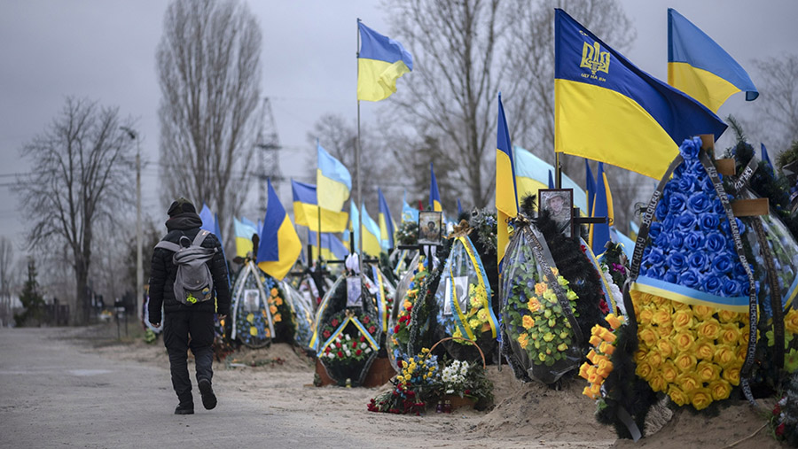 Warga mengunjungi makam tentara Ukraina yang gugur di pemakaman Lisove di Kyiv, Ukraina, Kamis (5/1/2023). (Andrew Kravchenko/Bloomberg)