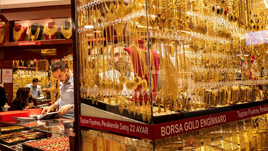 Seorang pekerja memeriksa emas yang dipajang di etalase toko perhiasan di Istanbul, Turki, Rabu (2/6/2021). (Nicole Tung/Bloomberg)