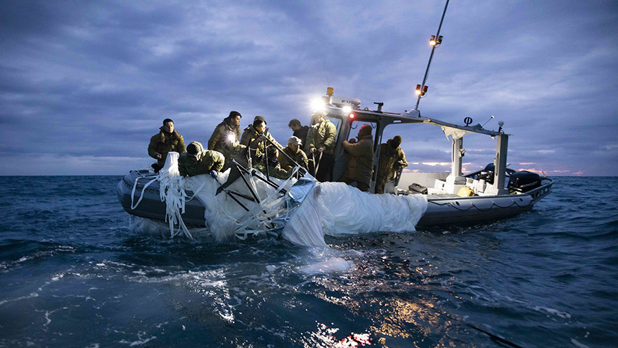 Tim Angkatan Laut AS memgangkat balon pengintai di lepas pantai Pantai Myrtle, S.C., Minggu (5/2/2023). (U.S. Navy/Thompson)