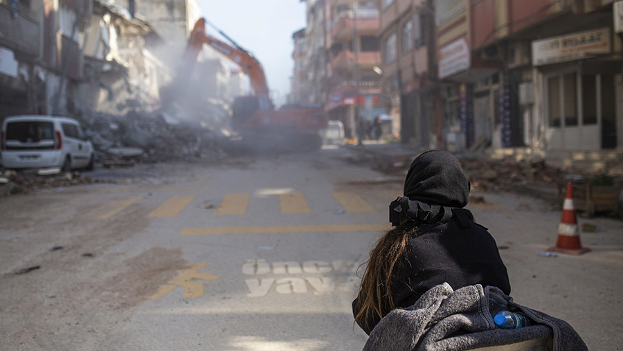 Ekskavator membersihkan puing-puing dari bangunan yang runtuh akibat gempa di Hatay, Turki, Rabu (8/2/2023). (Cansu Yildirann/Bloomberg)