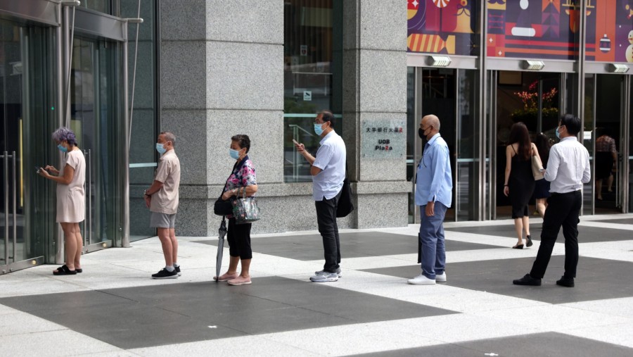 Warga mengenakan masker mengantri di luar bank di Singapura pada bulan Januari. (Sumber: Bloomberg)