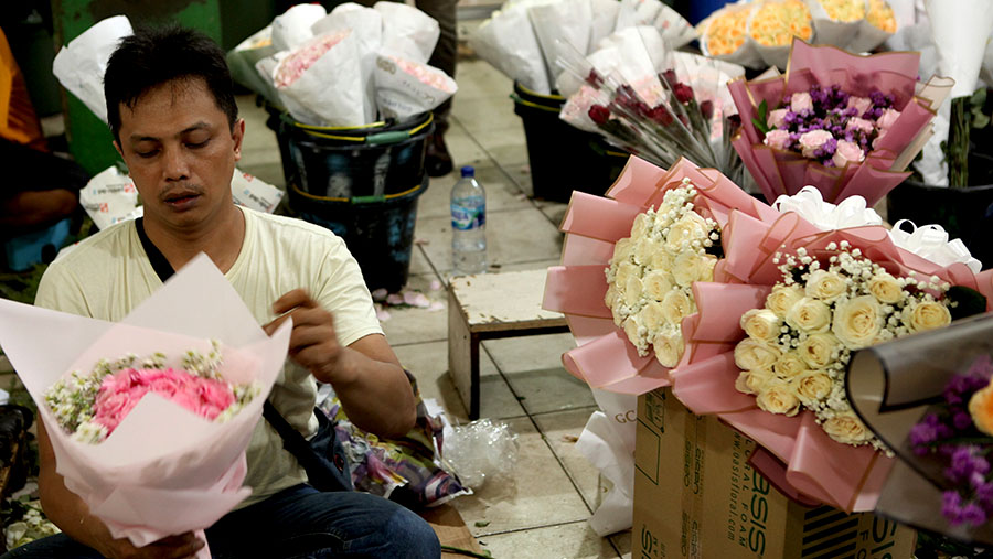 Pedagang merangkai bunga yang dijual di Pasar Bunga Rawa Belong, Jakarta, Selasa (14/2/2023). (Bloomberg Technoz/Andrean Kristianto)
