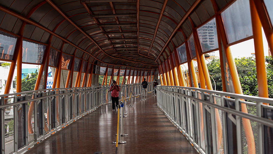 Warga berjalan di Skywalk Kebayoran Lama, Jakarta, Selasa (15/2/2023). (Bloomberg Technoz/ Andrean Kristianto)