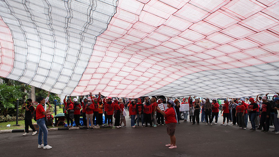 Dalam aksinya mereka membentangkan kain lap raksasa berukiran 15x15 meter sekaligus berorasi. (Bloomberg Technoz/ Andrean Kristianto)