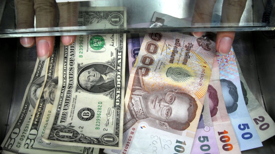Ilustrasi mata uang dolar AS dan baht Thailand (Udo Weitz/Bloomberg News)
