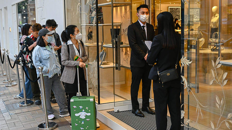 Pelanggan mengantri di luar toko Christian Dior SE di Hong Kong, Rabu (1/3/2023). (Billy H.C. Kwok/Bloomberg)