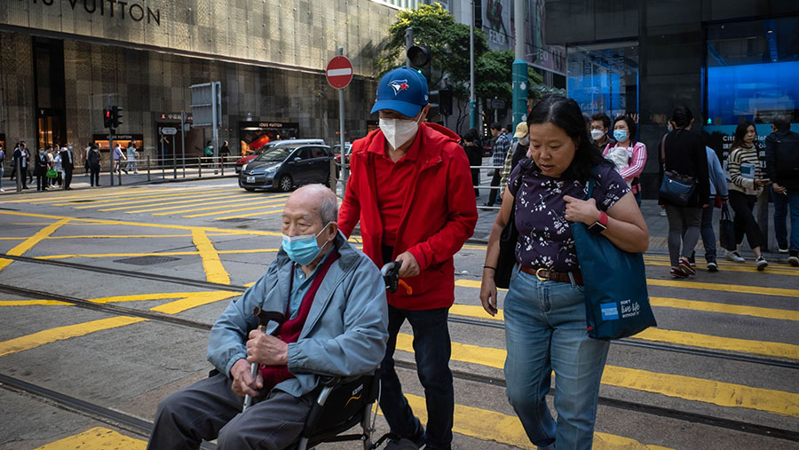 Namun, warga Hong Kong tetap menggunakan masker meskipun kewajiban pemakaiannya sudah dicabut oleh pemerintah setempat. (Billy H.C. Kwok/Bloomberg)