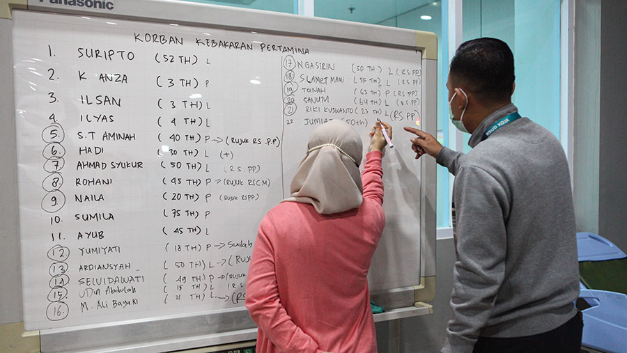 Petugas menulis daftar nama pasien kebakaran Depo Pertamina Plumpang di RSUD Koja, Jakarta, Sabtu (4/3/2023). (Bloomberg Technoz/ Andrean Kristianto)