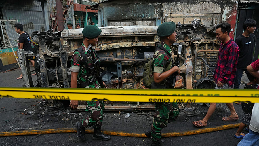 TNI berpatroli di pemukiman warga yang terbakar usai kebakaran di depo Pertamina Plumpang, Jakarta, Sabtu (4/3/2023). (Dimas Ardian/Bloomberg)