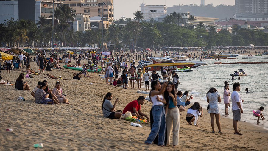 Wisatawan berlibur di pantai di Pattaya, Thailand, Minggu (5/3/2023). Thailand menyambut 2,14 juta turis asing pada Januari. (Andre Malerba/Bloomberg)