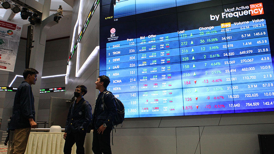 Pelajar berbincang di depan layar pergerakan saham (IHSG) di Bursa Efek Indonesia, Jakarta, Kamis (9/3/2023). (Bloomberg Technoz/ Andrean Kristianto)