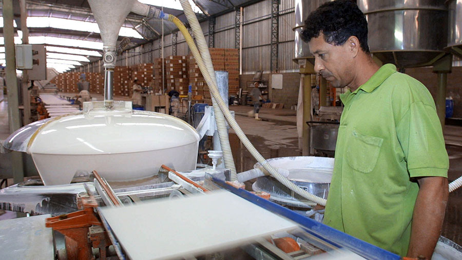 Seorang pekerja pabrik keramik mengoperasikan mesin. (Marcos Issa/Bloomberg News)