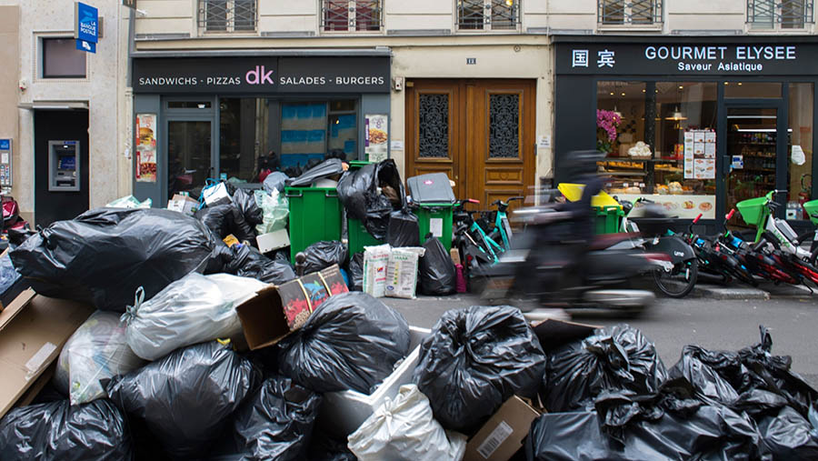 Akibat adanya aksi mogok, sejumlah sampah menumpuk di pinggir jalan. (Nathan Laine/Bloomberg)