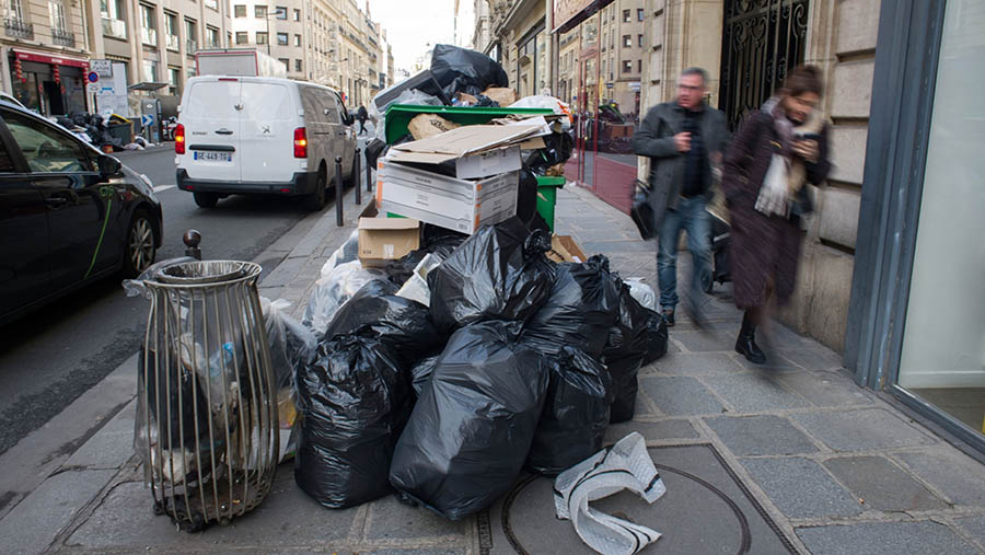 Tumpukan kantong dan kotak sampah berserakan di jalan di arondisemen ke-8 Paris, Prancis, Rabu (15/3/2023). (Nathan Laine/Bloomberg)