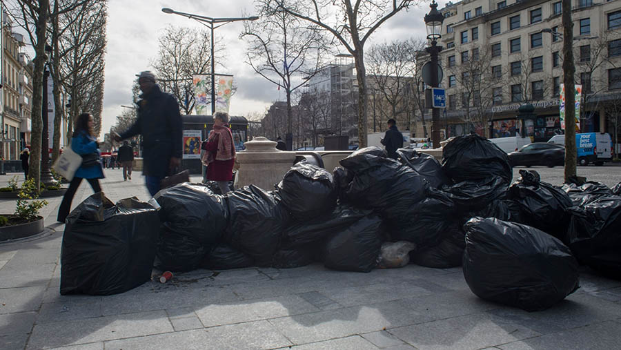 Para pekerja berhenti mengumpulkan sampah-sampah yang berada di kota itu. (Nathan Laine/Bloomberg)