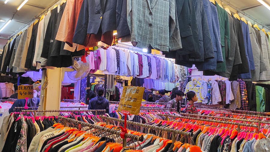 Calon pembeli memilih Thrifting pakaian bekas yang di jual di Pasar Senen, Jakarta, Kamis (16/3/2023). (Bloomberg Technoz/ Andrean Kristianto)