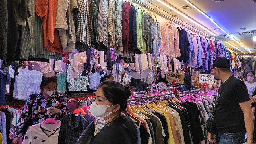 Calon pembeli memilih Thrifting pakaian bekas yang di jual di Pasar Senen, Jakarta, Kamis (16/3/2023). (Bloomberg Technoz/ Andrean Kristianto)