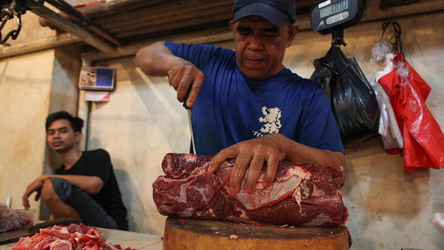 Penjual memotong daging sapi di pasar Senen, Jakarta Kamis (16/3/2023). (Bloomberg Technoz/ Andrean Kristianto)