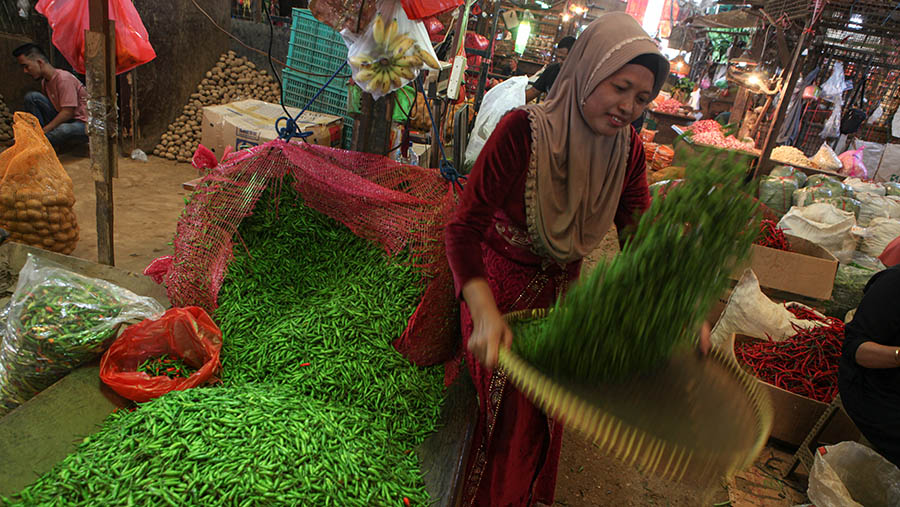 Pedagang memilih cabai rawit hijau di Pasar Induk Kramat Jati, Jakarta, Kamis (16/3/2023). (Bloomberg Technoz/ Andrean Kristianto)