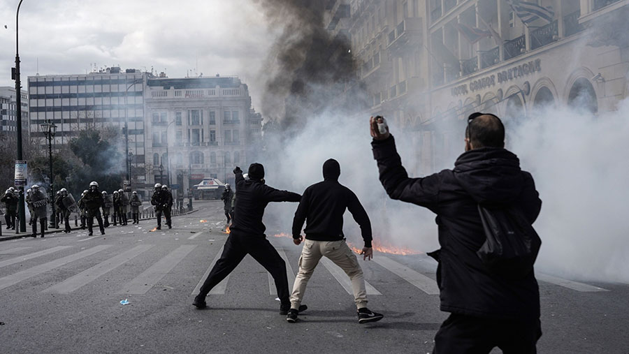 Bentrokan pedemo dan polisi saat demo memprotes standar keselamatan transportasi di Athena, Yunani, Kamis (16/3/2023). (Nick Paleologos/Bloomberg)