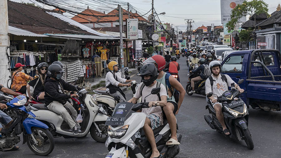 Turis asing mengendarai sepeda motor di Canggu, Bali, Kamis (16/3/2023). (Nyimas Laula/Bloomberg)
