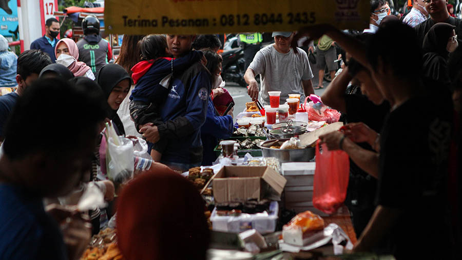 Pedagang melayani pembeli di pasar Ramadan Benhil, Jakarta Pusat, Jumat (24/3/2023). (Bloomberg Technoz/ Andrean Kristianto)