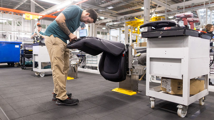 Karyawan menyelesaikan kursi depan SUV Aston Martin DBX di fasilitas manufaktur di St Athan, Inggris, Kamis (23/3/2023).  (Chris Ratcliffe/Bloomberg)