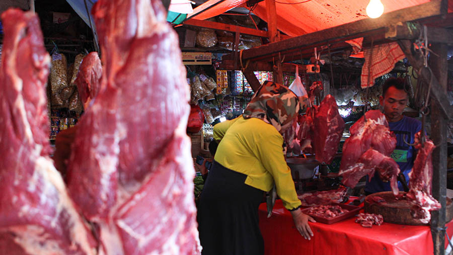 Pedagang melayani pembeli daging sapi di Pasar Kebayoran Lama, Jakarta, Senin (27/3/2023). (Bloomberg Technoz/ Andrean Kristianto)