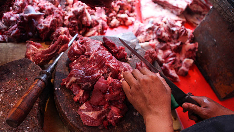 Pedagang memotong daging sapi di Pasar Kebayoran Lama, Jakarta, Senin (27/3/2023). (Bloomberg Technoz/ Andrean Kristianto)