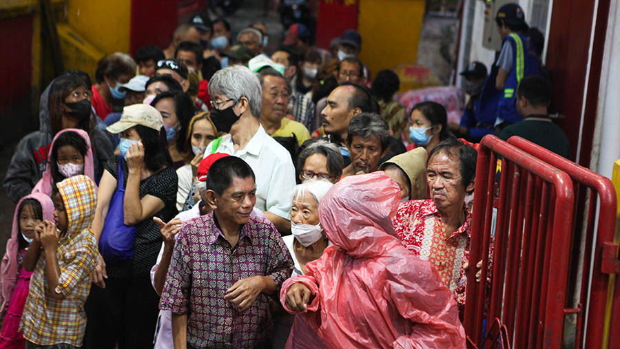 Warga antre untuk ambil makanan buka puasa di Vihara Dharma Bakti, Petak Sembilan, Jakarta, Rabu (29/3/2023). (Bloomberg Technoz/ Andrean Kristianto)