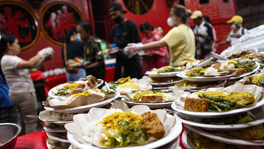 Warga antre untuk ambil makanan buka puasa di Vihara Dharma Bakti, Petak Sembilan, Jakarta, Rabu (29/3/2023). (Bloomberg Technoz/ Andrean Kristianto)