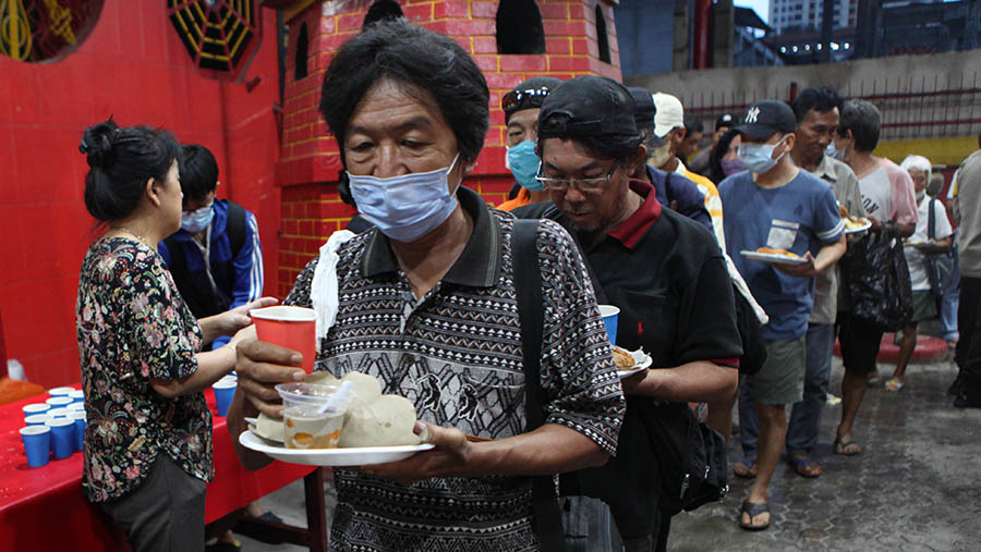 Para wargapun mengantre makanan dengan rapih. (Bloomberg Technoz/ Andrean Kristianto)