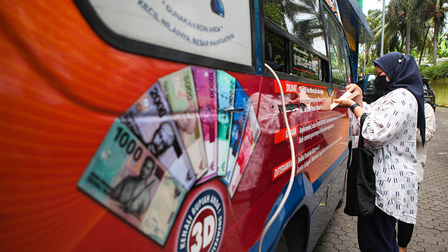Warga menukarkan uang tunai di layanan kas keliling Bank Indonesia di Pasar Tebet, Selasa (4/4/2023). (Bloomberg Technoz/ Andrean Kristianto)