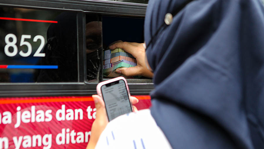 Warga menukarkan uang tunai di layanan kas keliling Bank Indonesia di Pasar Tebet, Selasa (4/4/2023). (Bloomberg Technoz/ Andrean Kristianto)