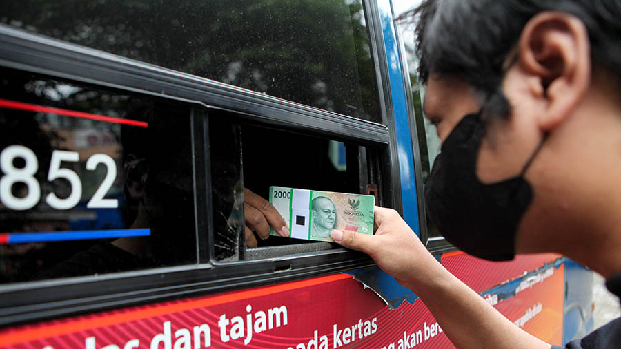 Warga menukarkan uang tunai di layanan kas keliling Bank Indonesia di Pasar Tebet, Selasa (4/4/2023). (Bloomberg Technoz/ Andrean Kristianto)
