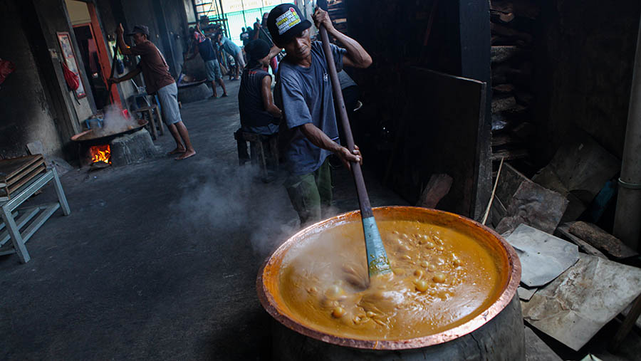 Dodol yang dimasak dalam wajan atau kuali besar diaduk dengan sodet panjang agar tidak gosong dan matang. (Bloomberg Technoz/ Andrean Kristianto)