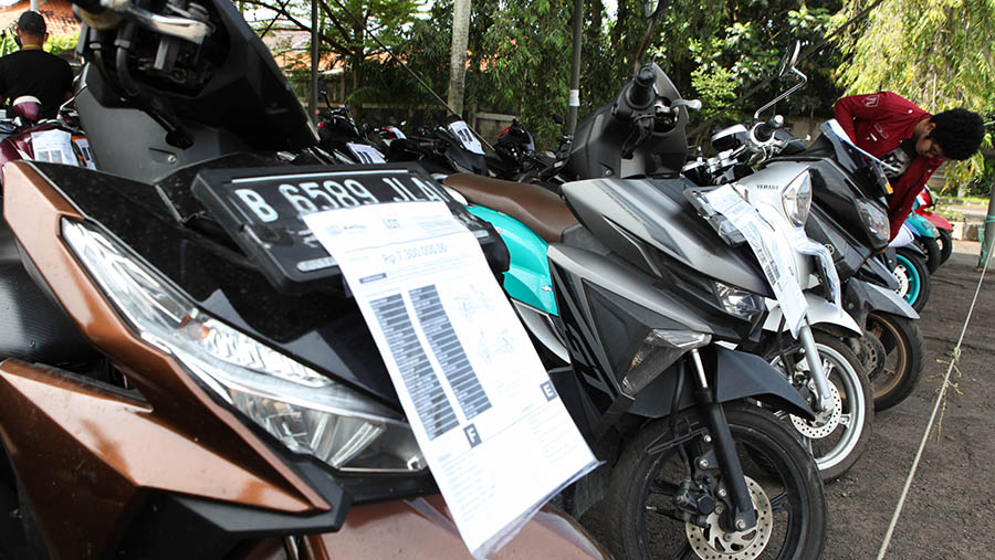 Peserta mengecek kondisi motor lelang di UC Auction, Ciputat, Tangerang Selatan, Kamis (6/4/2023). (Bloomberg Technoz/ Andrean Kristianto)