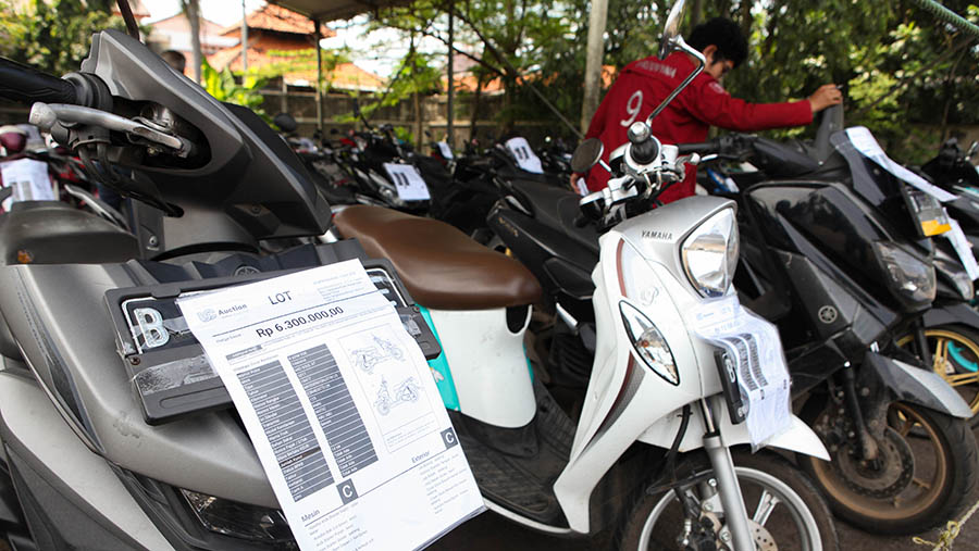 Peserta mengecek kondisi motor lelang di UC Auction, Ciputat, Tangerang Selatan, Kamis (6/4/2023). (Bloomberg Technoz/ Andrean Kristianto)
