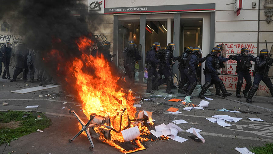 Bangku dibakar saat bentrokan polisi dan pedemo yang menentang reformasi pensiun di Paris, Prancis, Kamis (6/4/2023). (Nathan Laine/Bloomberg)