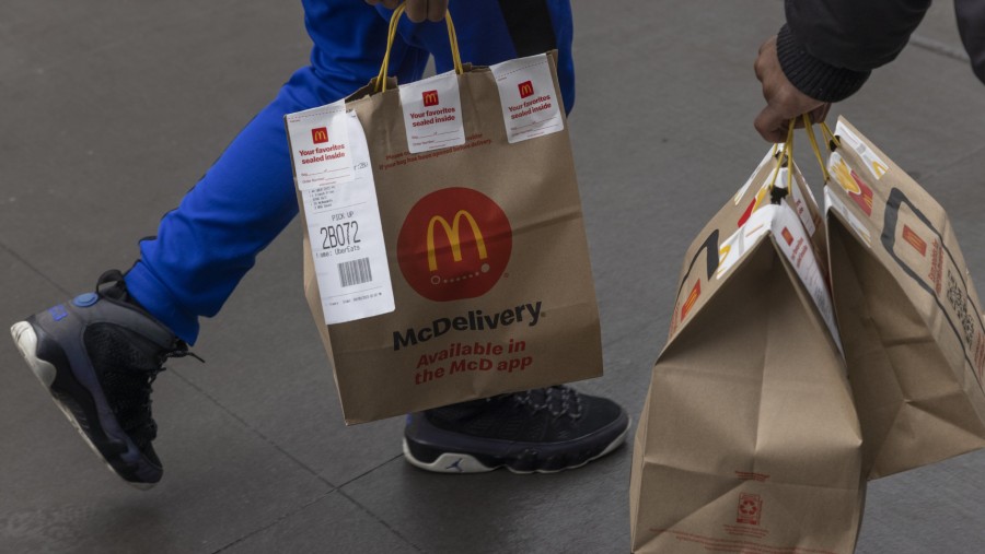 Konsumen McDonald's membawa hasil belanjaan dari restoran milik mereka di New York. (Dok Bloomberg)