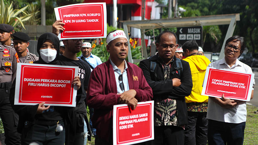Peserta aksi tolak #KPKDikorupsi membawa poster di Gedung Merah Putih KPK, Jakarta, Senin (10/4/2023). Bloomberg Technoz/ Andrean Kristianto)