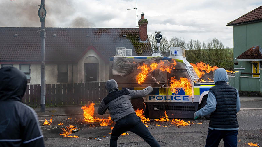 Massa dengan mengenakan topeng melempari bom molotov hingga mobil polisi tersebut terbakar. (Chris J. Ratcliffe/Bloomberg)