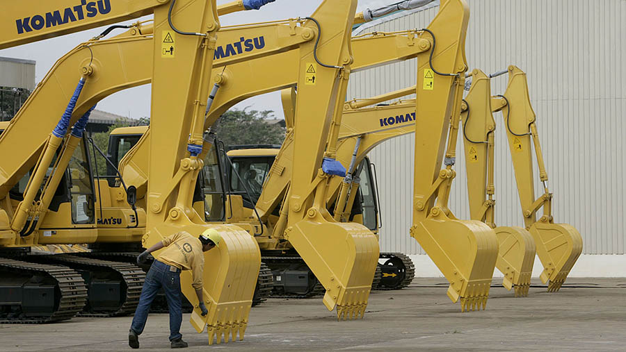 Pekerja PT United Tractors melihat ke front-end loader di Jakarta, Rabu (30/5/2023). (Dimas Ardian/Bloomberg)